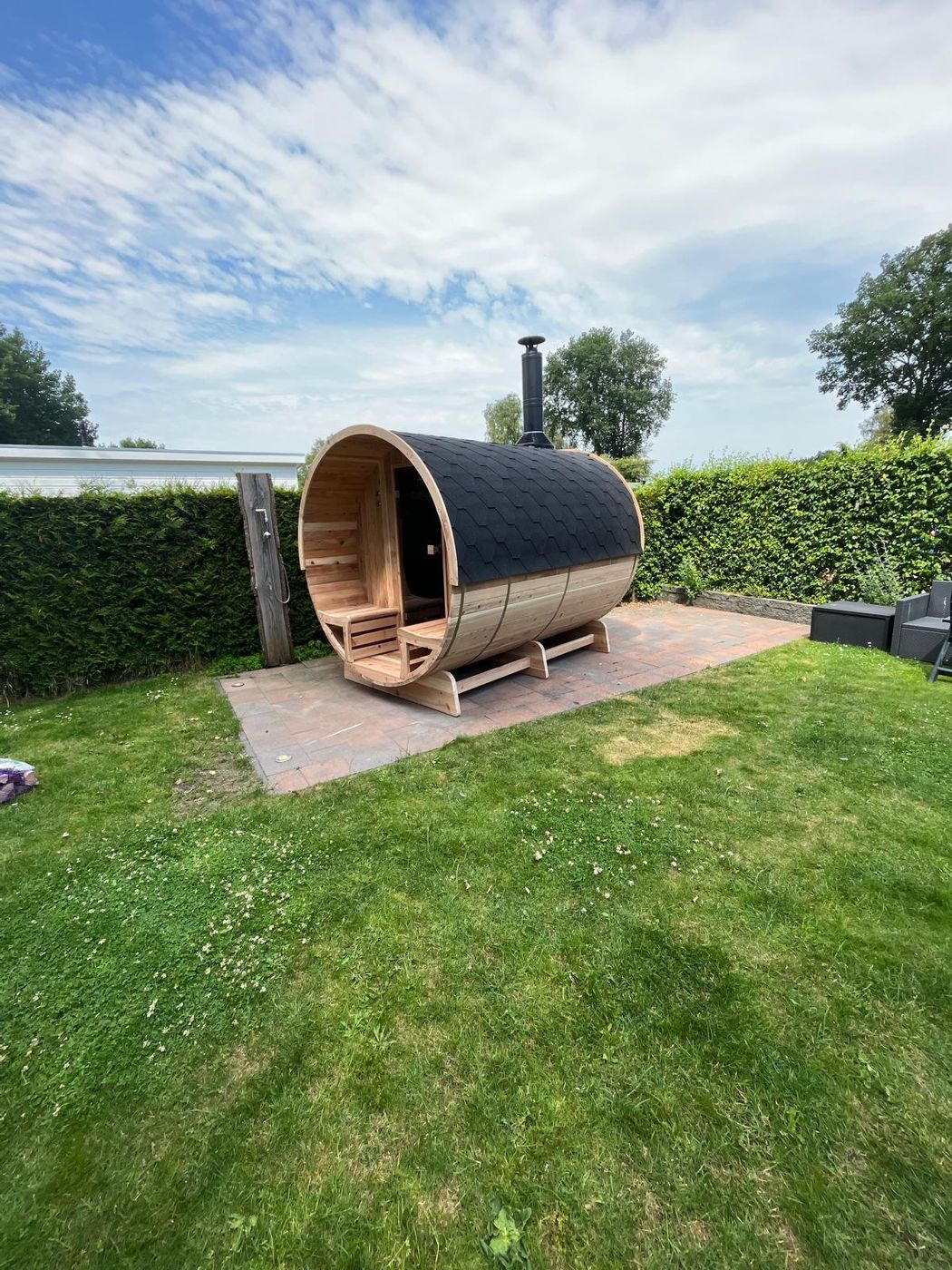 Barrelsauna geplaatst op een terras in de tuin