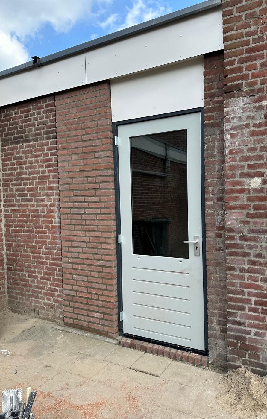 Nieuwe buitendeur in een doorbroken en opnieuw gemetselde gevel