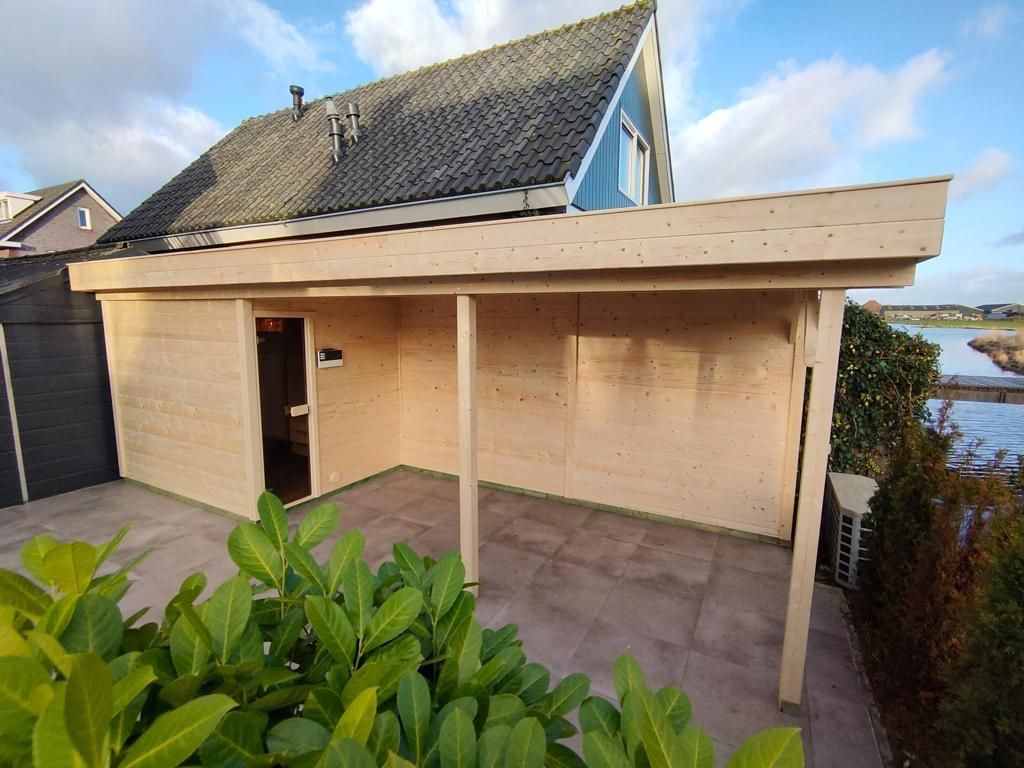 Houten overkapping met berging, gebouwd aan het water